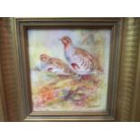 A hand-painted porcelain plaque depicting two partridges in a naturalistic setting, signed