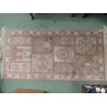 An Oriental rug with tasselled ends. 140cm long x 70cm wide