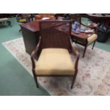 A pair of Edwardian mahogany Bergere armchairs on spade foot tapering fore legs