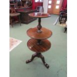 A Georgian revival mahogany three tier dumb waiter the dished circular tops on a turned column and