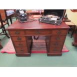 A late Victorian "James Shoolbred" walnut twin pedestal desk of nine drawers on a plinth base and