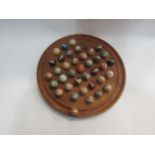 A solitaire board with polished gem stone marbles, 37cm diameter