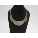 A white metal three segment necklace with basket weave design