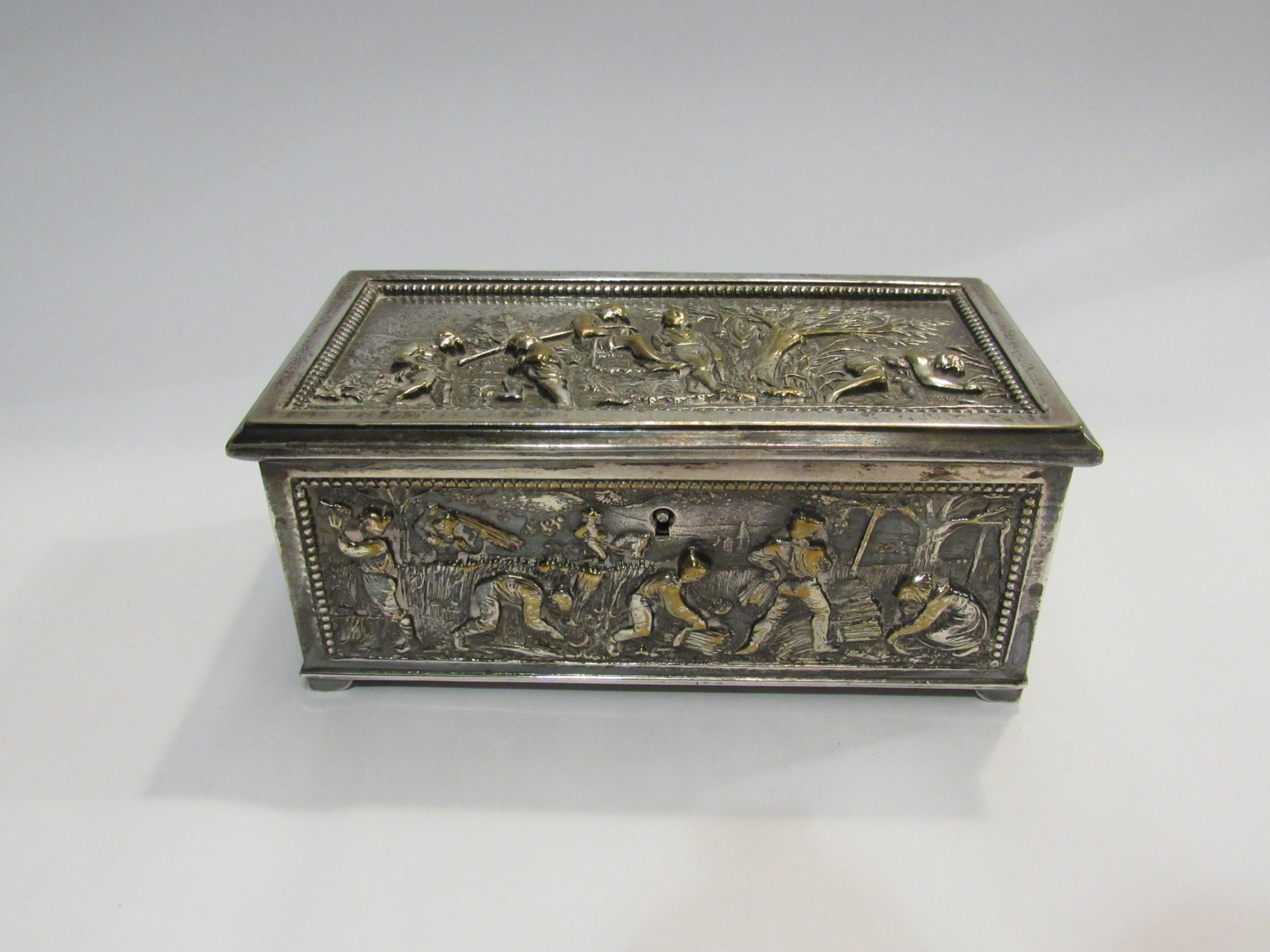 A silver plated lidded box with scenes of farmers