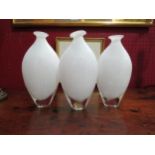 A set of three handblown white glass vases, 22cm tall