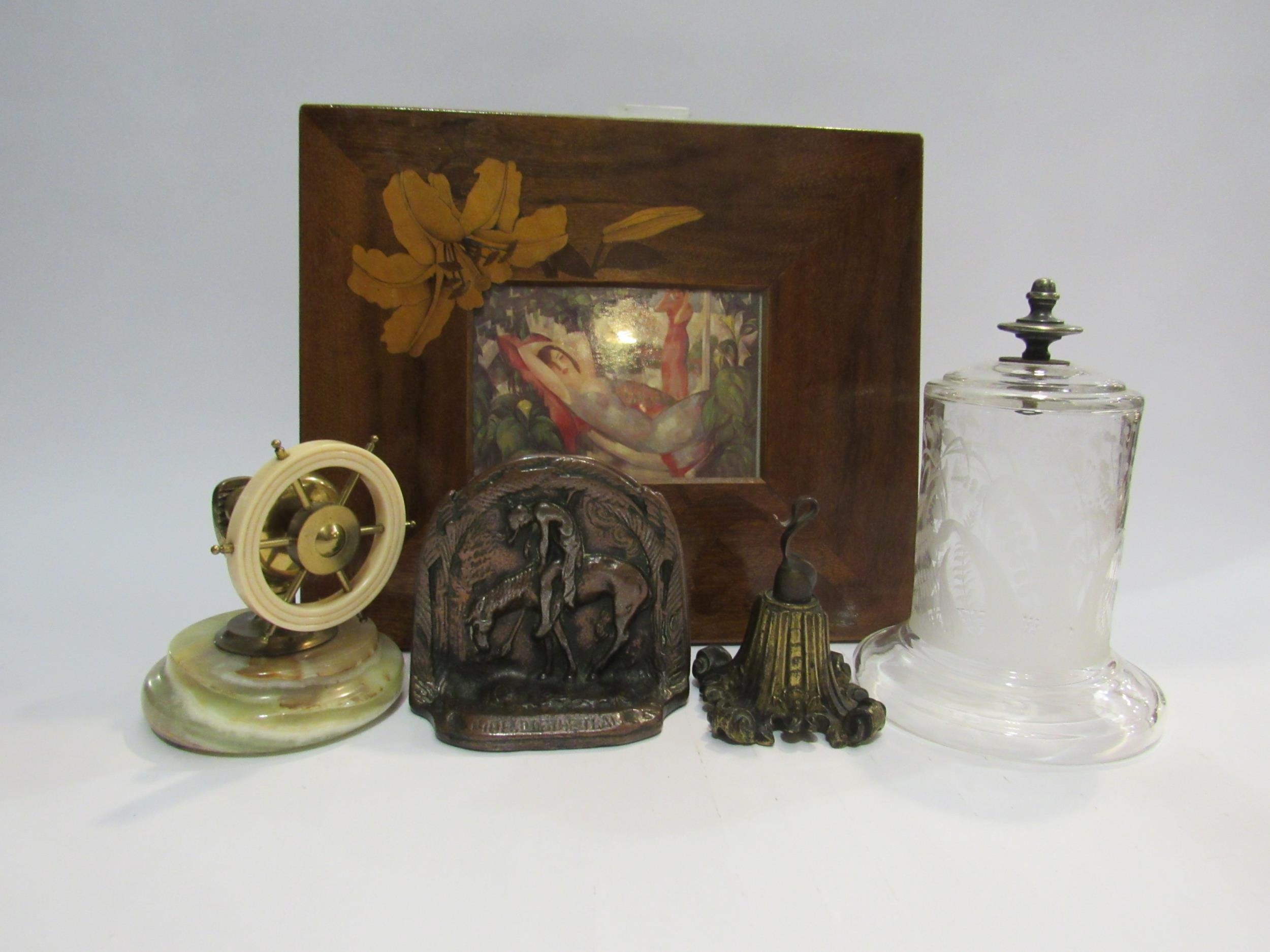 A pair of cast metal bookends, a glass watch dome, a watch holder, ships wheel nutcracker and