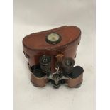 A pair of WWII US Signal Corps binoculars with brown leather case incorporating a compass to the lid