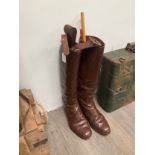 A pair of brown leather military boots together with a half height pair of black leather boots,