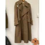 A 1950's British Army Officer's greatcoat, yellow piping, plain buttons the label marked 2nd/Lt. D.