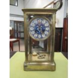 A brass four-glass mantel clock, beveled glass panels, French movement with logo for Victor