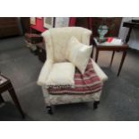 A late Edwardian wingback armchair with foliate upholstery on castors