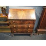 A Victorian flame mahogany bureau, the fall front over three drawer front, bun handles, turned