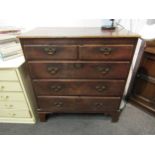 A Georgian oak country chest of two short over three long graduating drawers, brass shaped