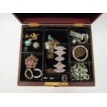 A large jewellery box with contents including ringsm brooches, pendants, necklaces, etc