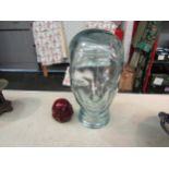 A glass head, 29cm high, together with a buddha head (2)