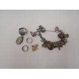 A silver charm bracelet hung with various charms including elephant, teapot, Mr Whippy '99, with
