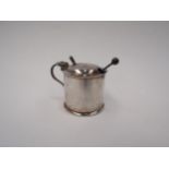 A silver mustard pot and spoon