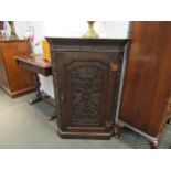 A Victorian oak corner cupboard with foliate and Tudor Rose carved door, wavy shelved interior,