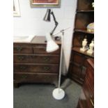 A white floor standing reading lamp and a black adjustable table lamp