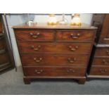 A George III mahogany chest of two short over three long drawers, brass swan neck handles, on