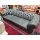 A large black leather Chesterfield sofa