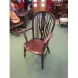 A 19th Century elm and ash hoop back Windsor armchair with central wheel splat the saddle seat