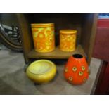 A 1960's set of three graduated storage containers, a German red glazed speckled vase and a Bretby
