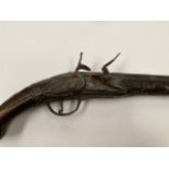 A late 18th Century flintlock pistol with all over scrolled foliate carving, part of mechanism