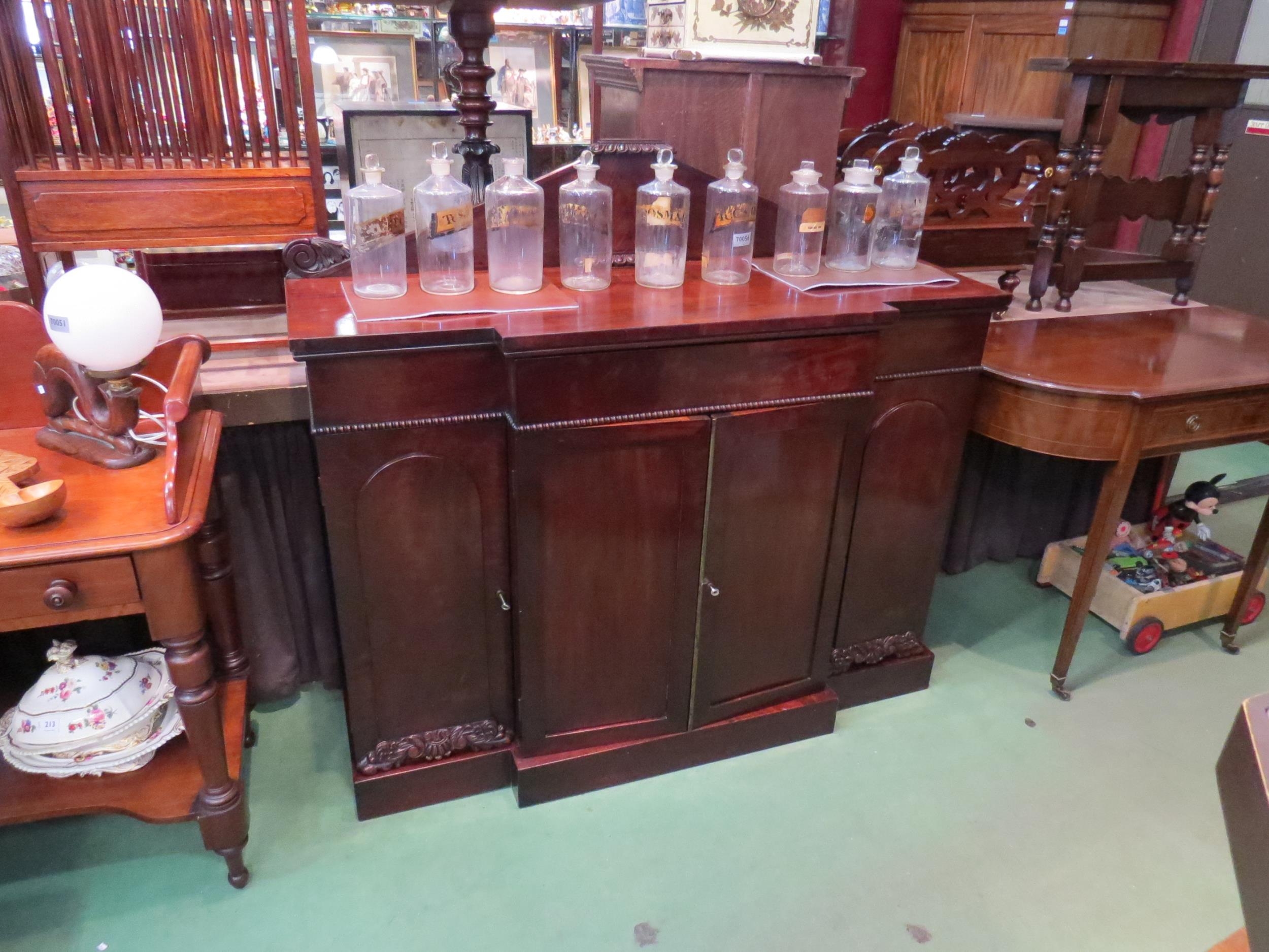 Circa 1820 a Regency flame mahogany breakfront sideboard with central frieze drawer over a four door