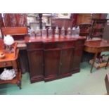 Circa 1820 a Regency flame mahogany breakfront sideboard with central frieze drawer over a four door
