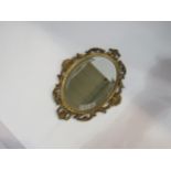 An Italian gilt metal oval bevel edge mirror with ornate frame, 24cm high x 18cm wide total