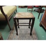 An 18th Century style oak stool the rush seat over straight cabriole legs on ball feet joined by