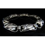 A Continental silver bracelet with seven panels having a leaf and berry motif, 13.6g
