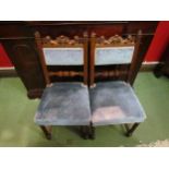 In the manner of "Gillows" a pair of Victorian walnut chairs with carved lions holding a shield with