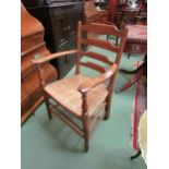 An Arts & Crafts Cotswold school oak ladder back armchair with rush seat and turned fore legs united
