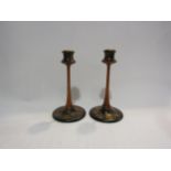 In the manner of "Liberty & Co.," a pair of painted fruitwood candle sticks with turned sconces on