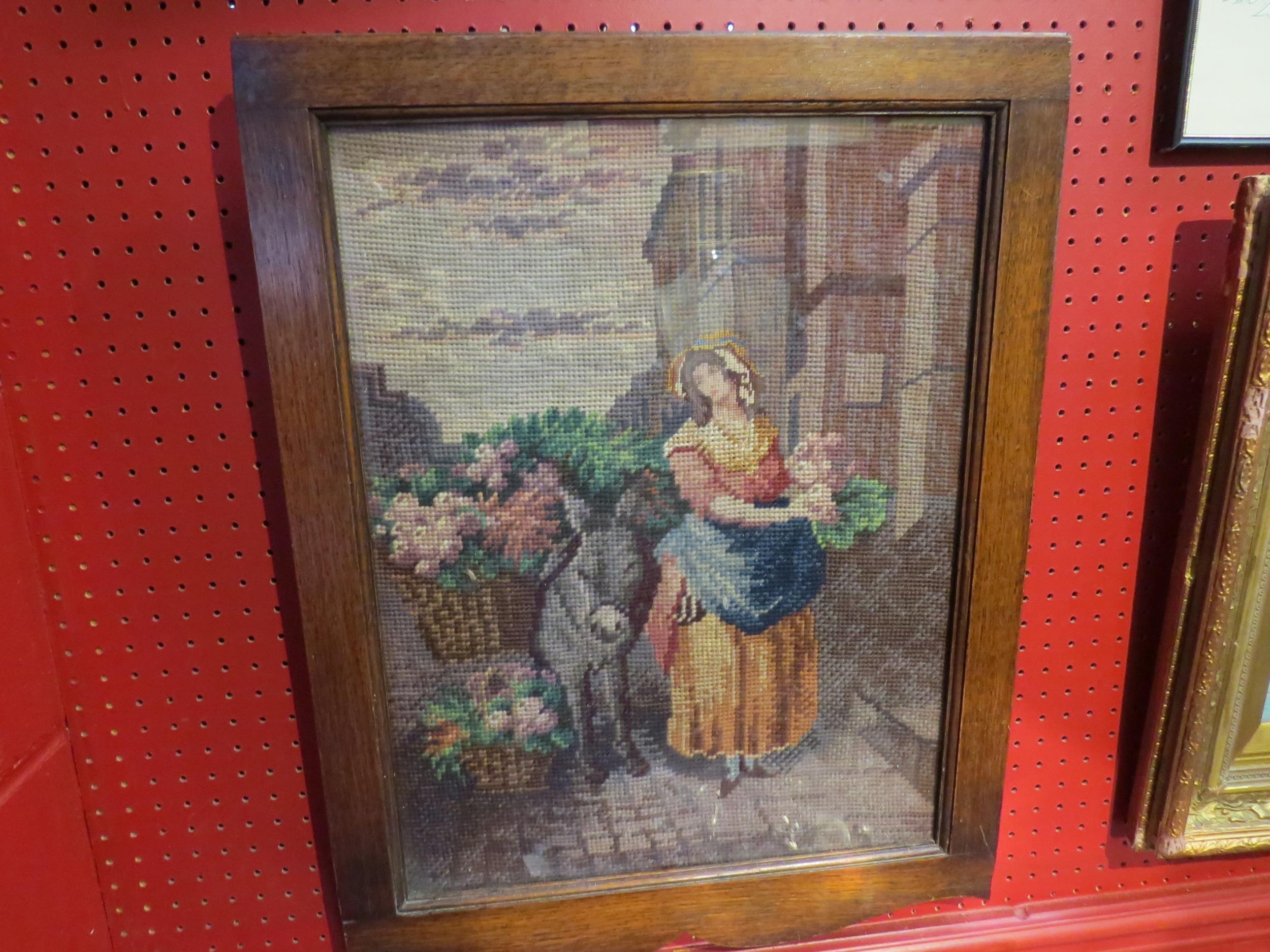 A vintage oak framed Irish woolwork picture from Co. Wexford of a woman standing beside a donkey