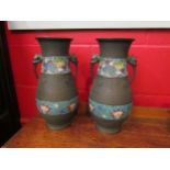 A pair of metal vases with decorative impressed marks and cloisonne enamel bands, twin mythical