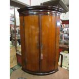 A circa 1790 Lancashire cross banded mahogany and oak bow front corner cupboard, the two doors