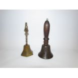 Two brass handbells, one of Oriental form with figural finial