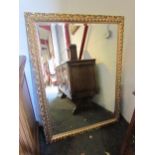 A large modern gilt rectangular hall mirror with acanthus scroll detail, bevelled glass. 89cm x