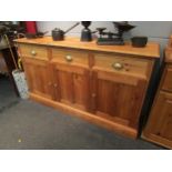 A pine dresser base with three drawers over three door cupboard, 87cm high x 152cm wide x 45cm deep