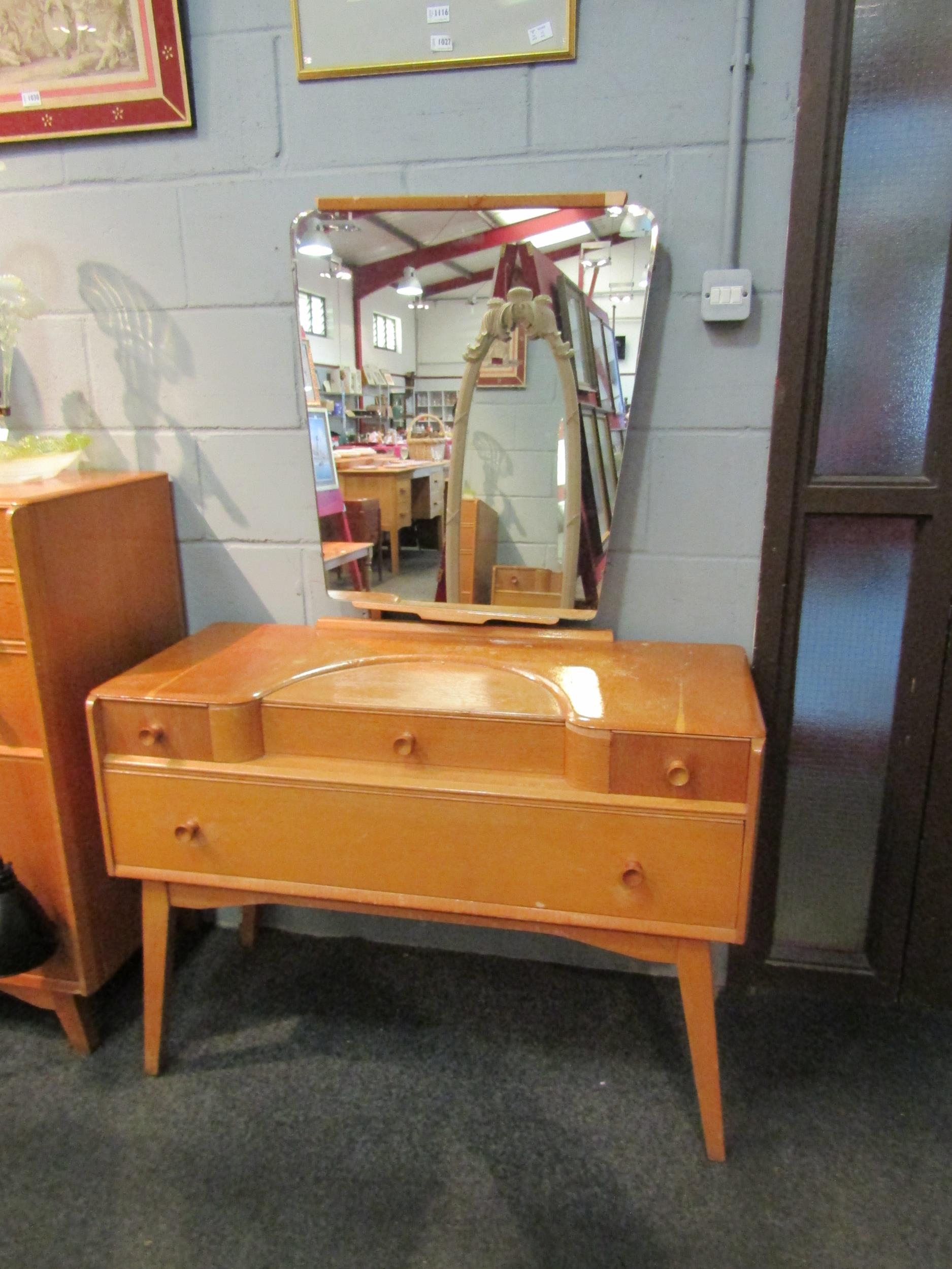 A 1960s Austinsuite light oak dressing table with four drawers, mirror back and splayed legs,