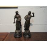 A pair of spelter bronze effect figures of ladies holding baskets of flowers. 32cm high