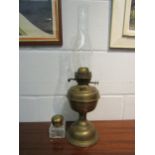 A brass based oil lamp and a glass inkwell with brass lid