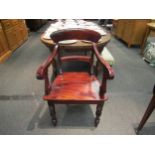 A Victorian style mahogany armchair with carved decoration