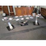 A set of three designer occasional tables, the bevel edge tops on tapering stainless steel
