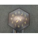 A mid-Century oak wall clock, hexagonal case with beaded surround and brass Arabic numerals, wind-up