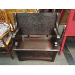 A late Victorian carved oak box seat hall settle the pegged hinged table top on shaped slab supports
