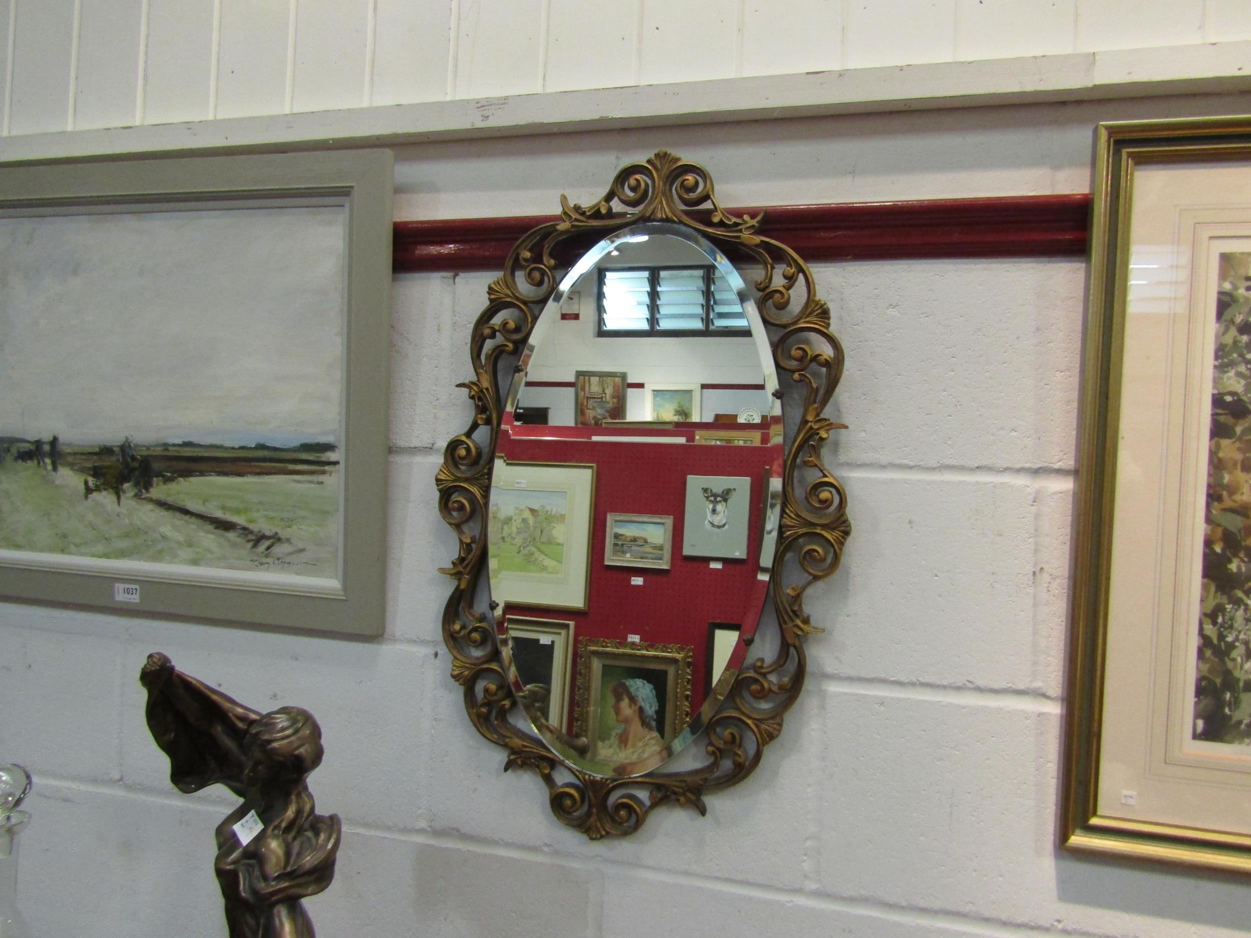 An oval gilt framed wall mirror, 75cm x 46cm total